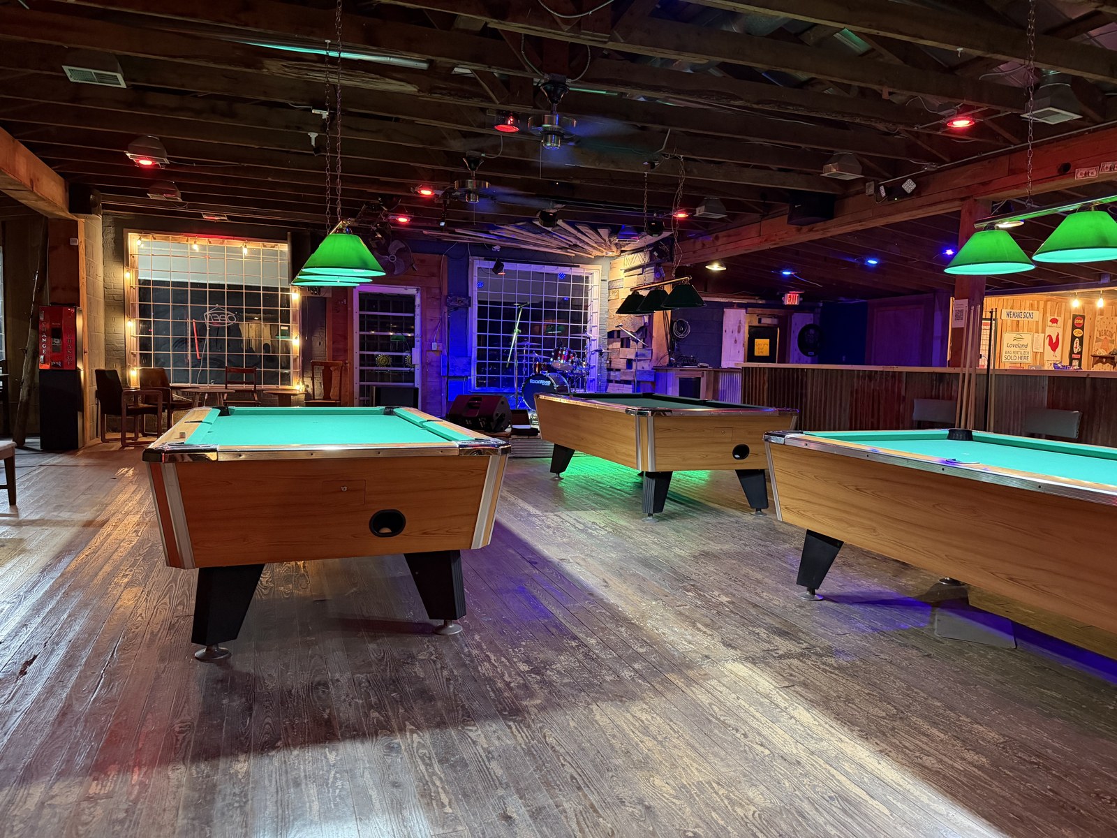 Pool tables with green lamps inside Backbeat